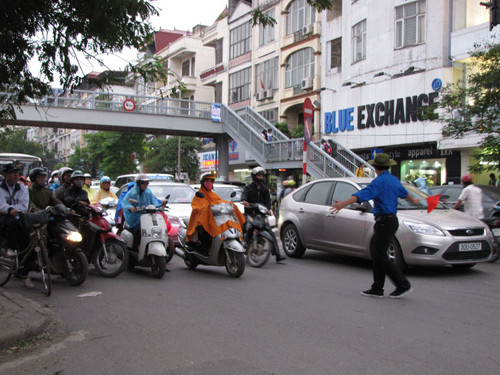 Dũng cảm đứng trước mũi các phương tiện giao thông. Ảnh: Lãng Phong