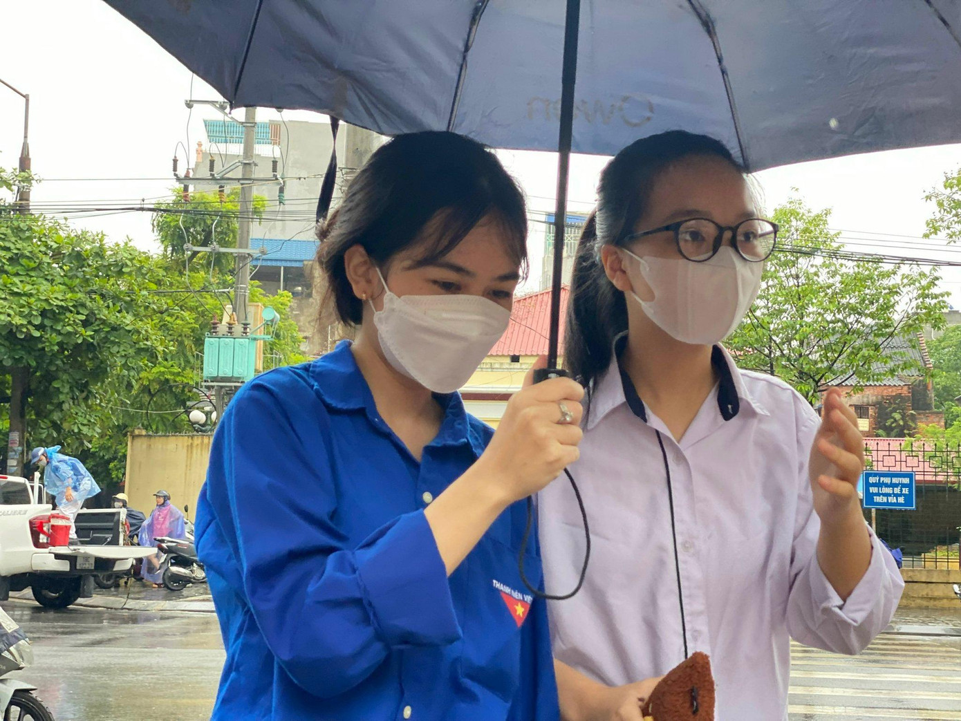 Tình nguyện viên che ô cho thí sinh Tình nguyện viên che ô cho thí sinh