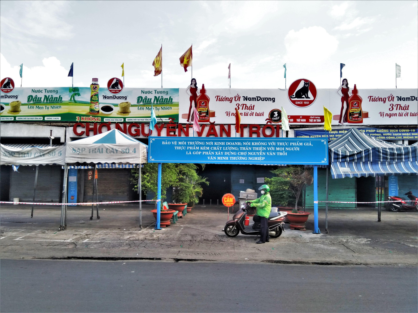 Chợ Nguyễn Văn Trỗi ở quận 3 bán nhiều hàng hóa "Made in Việt Nam" phục vụ nhiều người dân các quận 3 và Tân Bình hiện cũng ngừng hoạt động để chống dịch. Trong ảnh: Một người giao hàng duy nhất xuất hiện ở cổng chợ Nguyễn Văn Trỗi trong ngày cách ly xã hội.