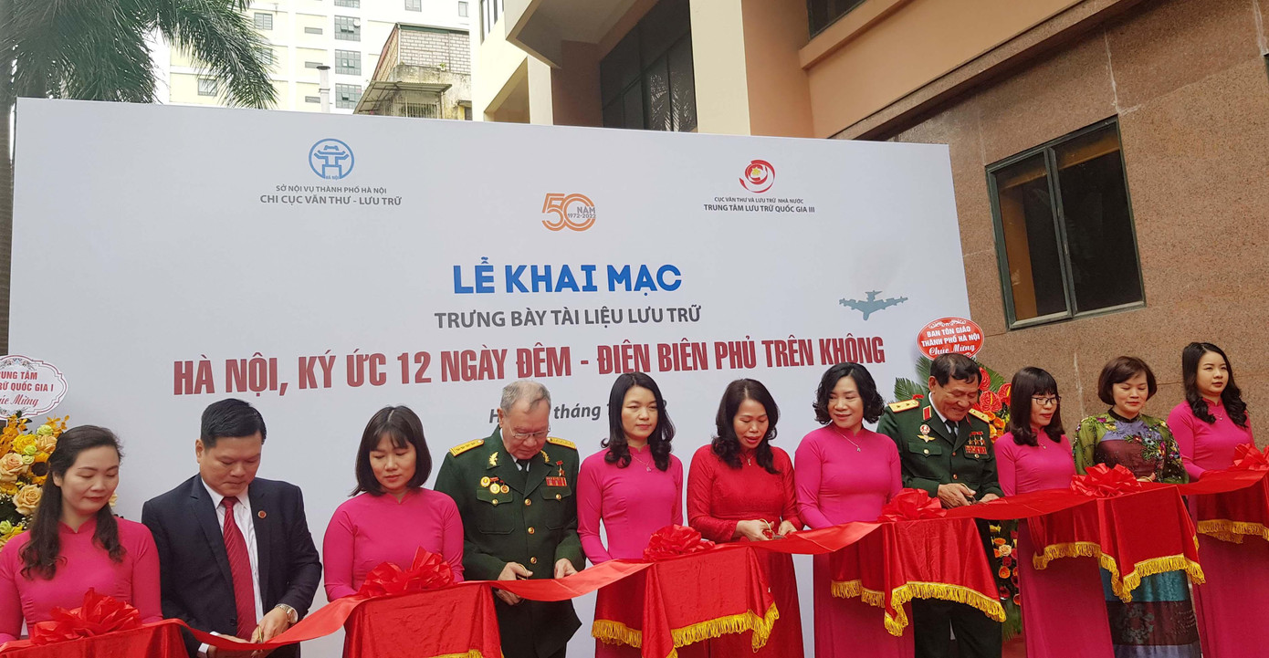 Anh hùng Phạm Tuân (thứ tư từ phải sang), Anh hùng Nguyễn Đình Kiên (thứ tám từ phải sang) cùng các đại biểu cắt băng khánh thành cuộc Trưng bày tài liệu lưu trữ "Hà Nội, ký ức 12 ngày đêm - Điện Biên Phủ trên không". Ảnh: Kiến Nghĩa