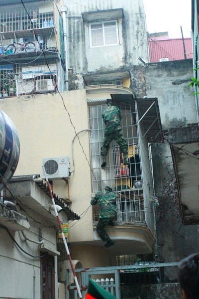 Các chiến sỹ trèo tường để tiếp cận hiện trường