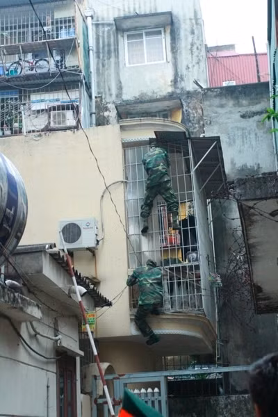 Các chiến sỹ trèo tường để tiếp cận hiện trường