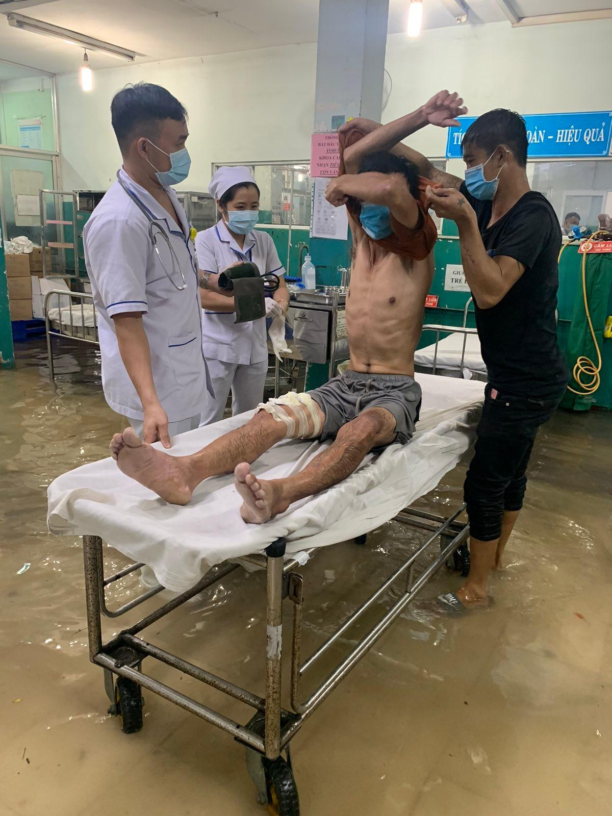 Nhân viên bệnh viện cho biết, cứ mưa lớn là họ phải lội nước làm việc như vậy trong nhiều năm qua. Ảnh Q.Q