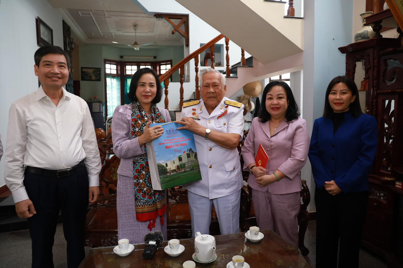 Phó Chủ tịch Quốc hội Nguyễn Thị Thanh (thứ 2 bên trái ảnh) tặng quà Anh hùng LLVTND Hồ Đắc Thạnh.