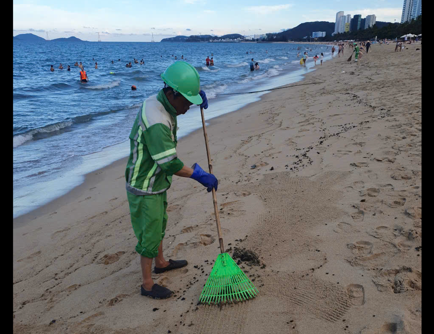 Nhân viên vệ sinh môi trường dọn dẹp dầu vón cục dạt vào bờ biển. Nhân viên vệ sinh môi trường dọn dẹp dầu vón cục dạt vào bờ biển.