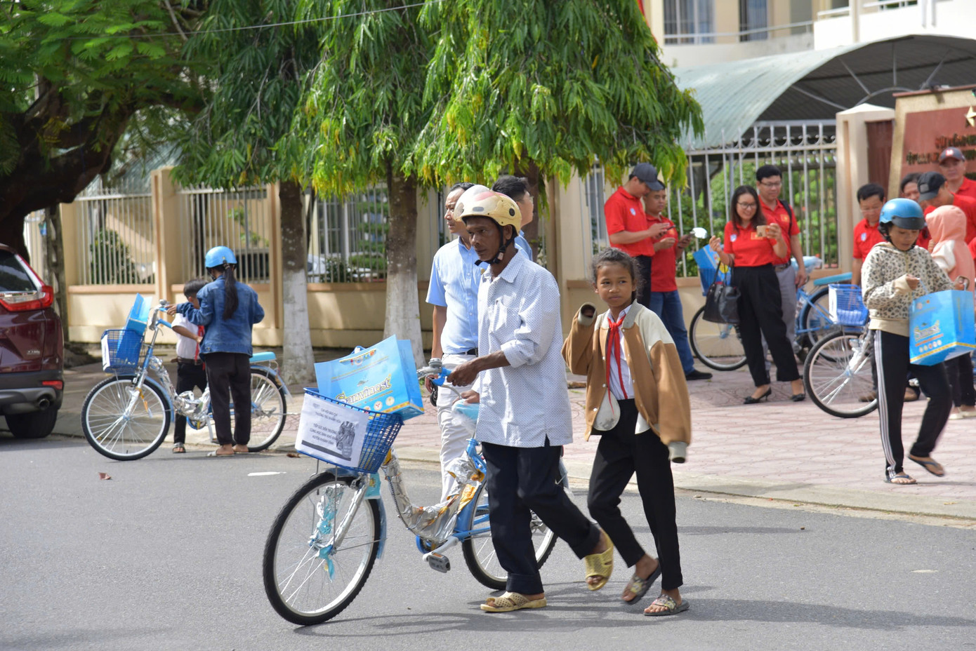 Học sinh và phụ huynh đưa xe đạp về nhà. Học sinh và phụ huynh đưa xe đạp về nhà.