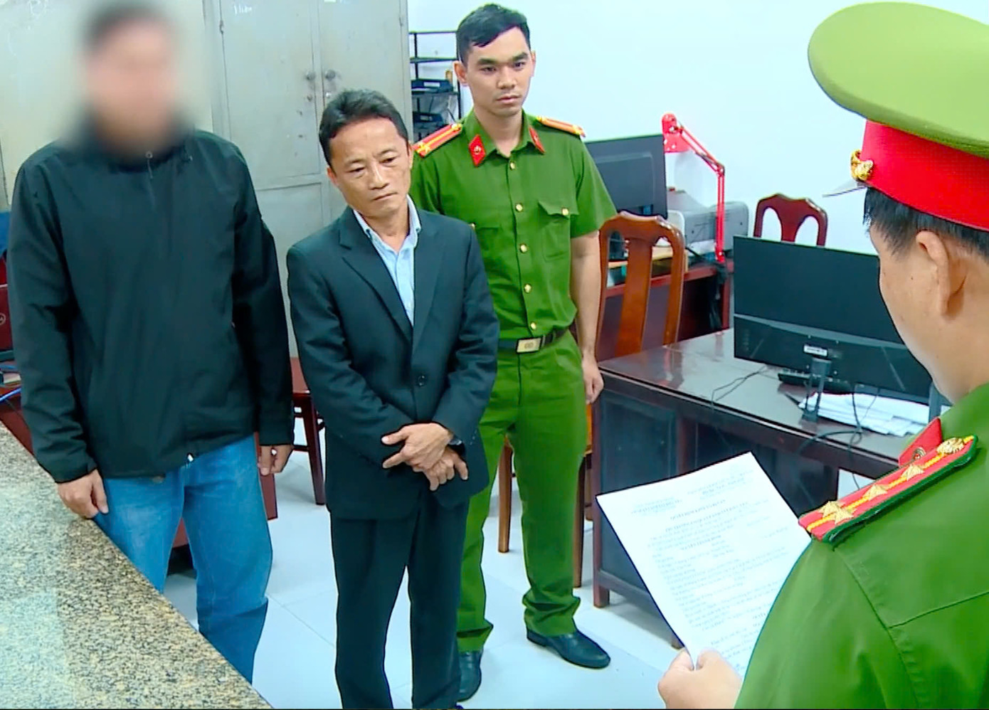 Nguyễn Thanh Bình (thứ 2 bên trái) nghe đọc lệnh khởi tố, bắt tạm giam. Ảnh: CACC.