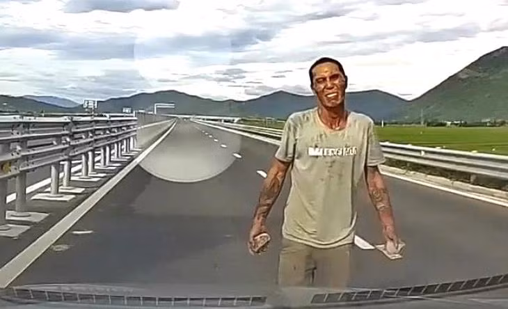Người đàn ông cầm đá, chặn đầu xe trên cao tốc Vân Phong - Nha Trang: Ảnh cắt từ clip. Người đàn ông cầm đá, chặn đầu xe trên cao tốc Vân Phong - Nha Trang: Ảnh cắt từ clip.