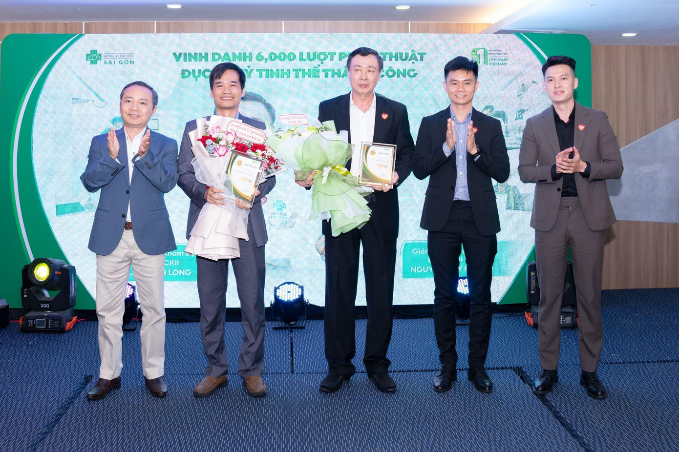 Đại diện Ban lãnh đạo Tập đoàn Y khoa Sài Gòn trao tặng bằng vinh danh cho Bác sĩ Nội Trú Nguyễn Huy Hoàng và Bác sĩ CKII Lê Thanh Long tại sự kiện
