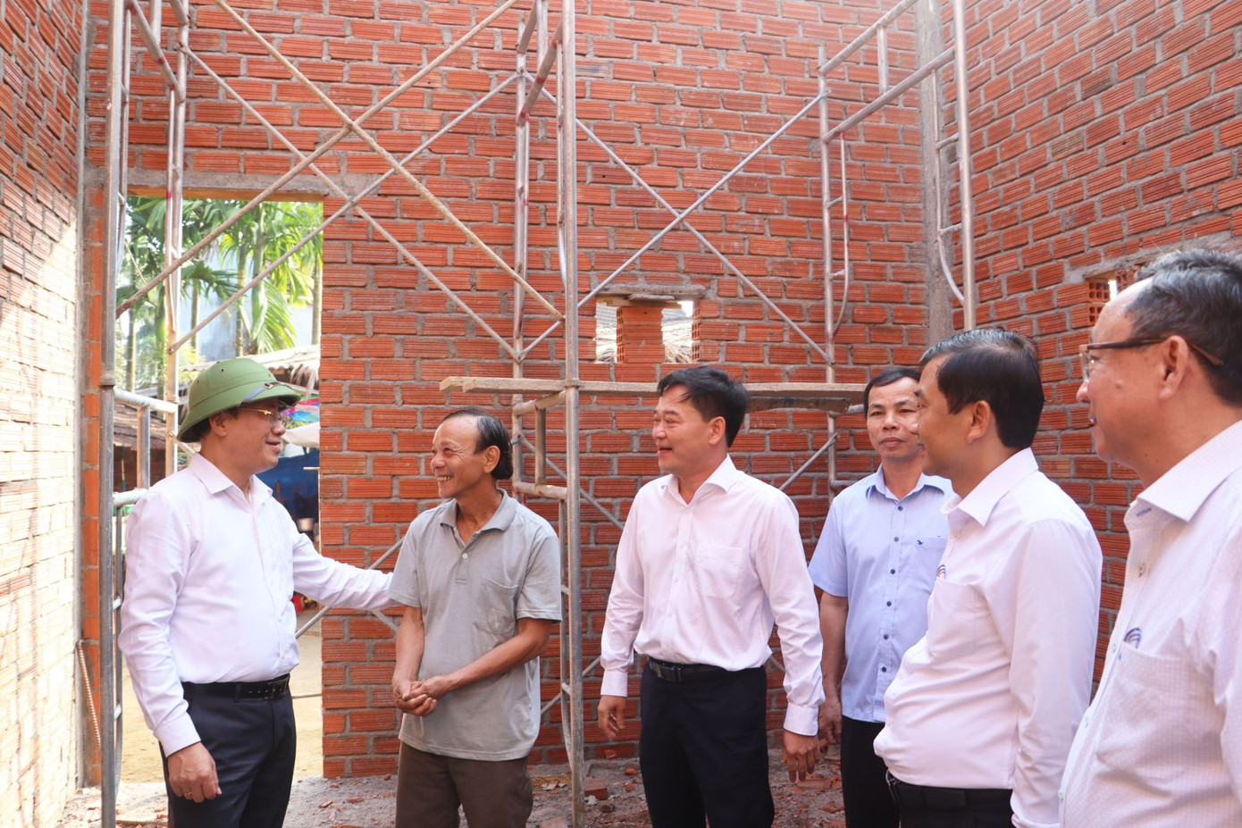 Chủ tịch UBND tỉnh Bình Định Phạm Anh Tuấn (đội mũ xanh) đi kiểm tra tình hình xóa nhà tạm, nhà dột nát tại các địa phương