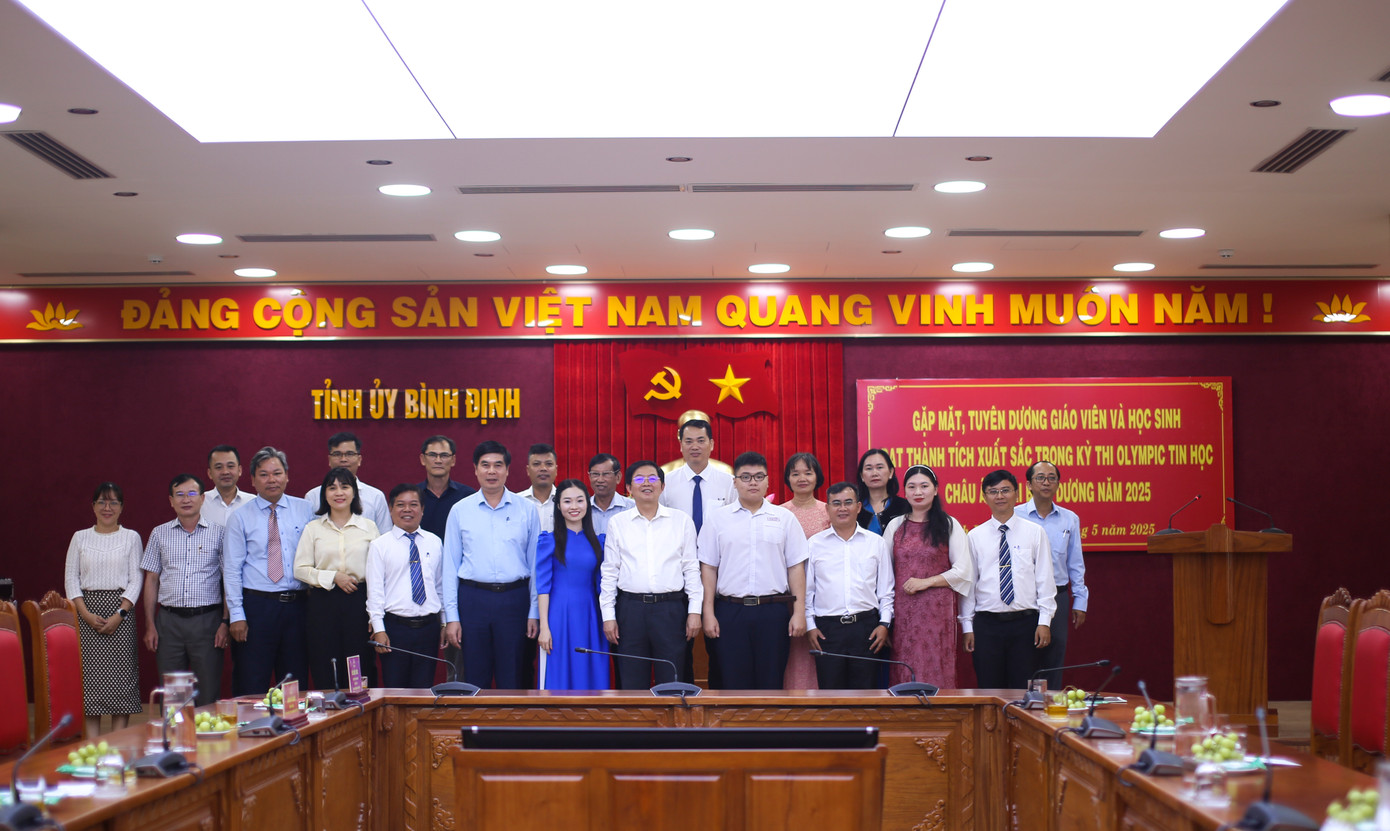 Các đại biểu chụp hình kỷ niệm cùng em Lê Kiến Thành, gia đình và nhà trường. Ảnh: Trương Định