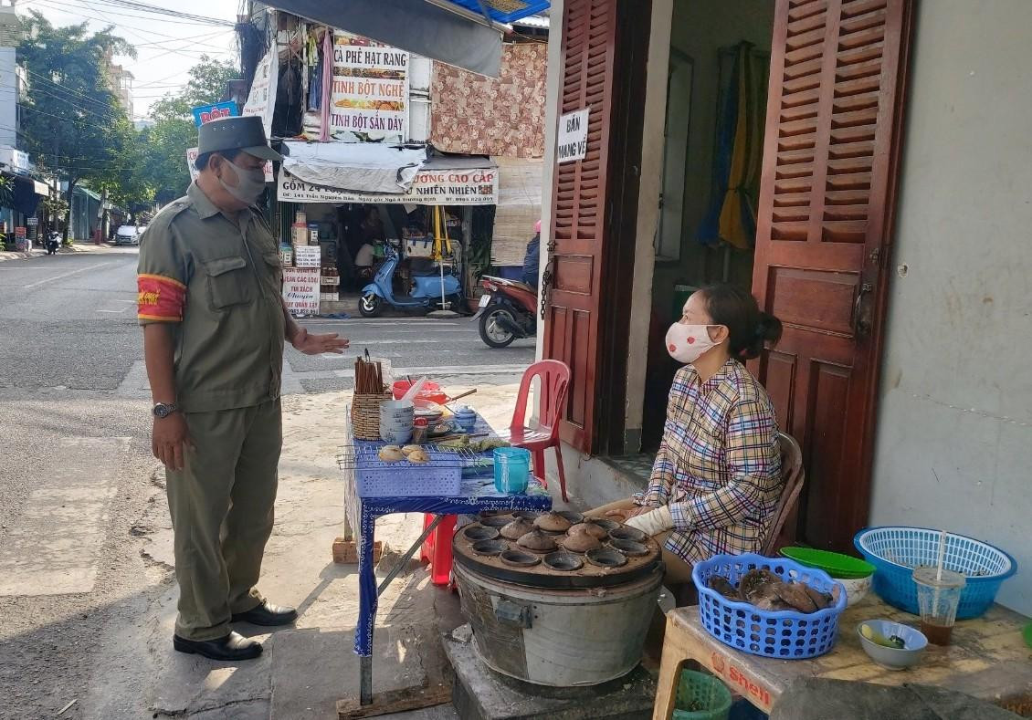 Lực lượng bảo vệ dân phố nhắc nhở người bán hàng trên vỉa hè TP Nha Trang. Ảnh LỮ HỒ.