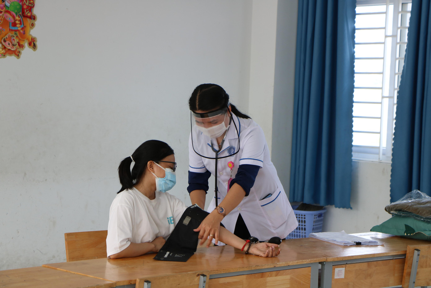 Nhân viên y tế Ninh Thuận kiểm tra sức khoẻ người dân trong khu cách ly. Ảnh CÔNG HOAN