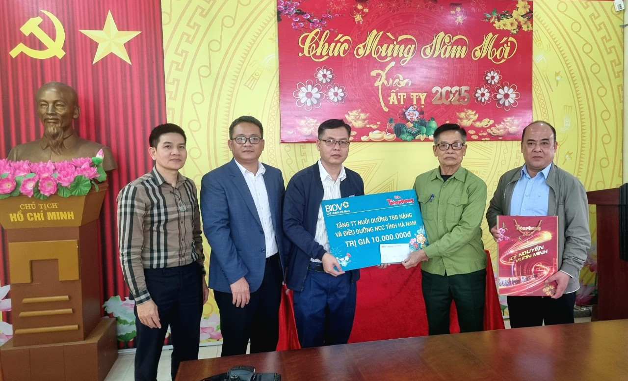 Ông Phạm Nghi Sơn, Phó Giám đốc BIDV Hà Nam và nhà báo Hồ Sỹ Lực trao quà đến các bác thương binh Trung tâm điều dưỡng thương binh Liêm Cần.