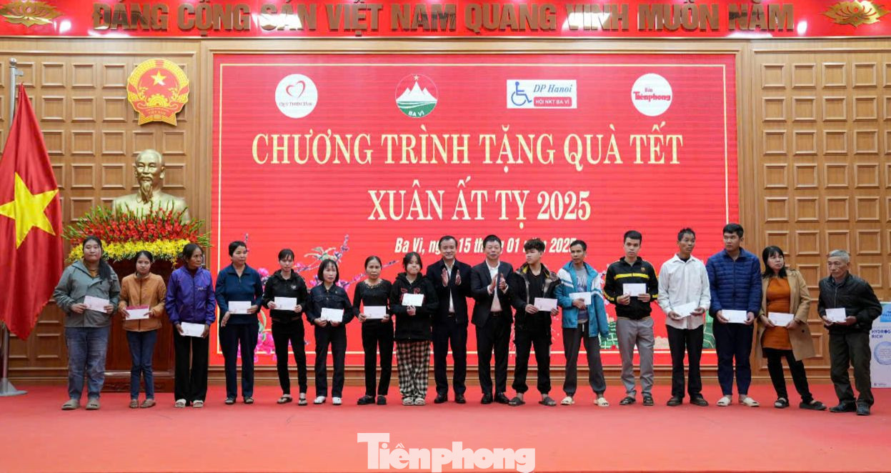 Nhà báo Phùng Công Sưởng và ông Đỗ Mạnh Hưng trao quà đến người khuyết tật.