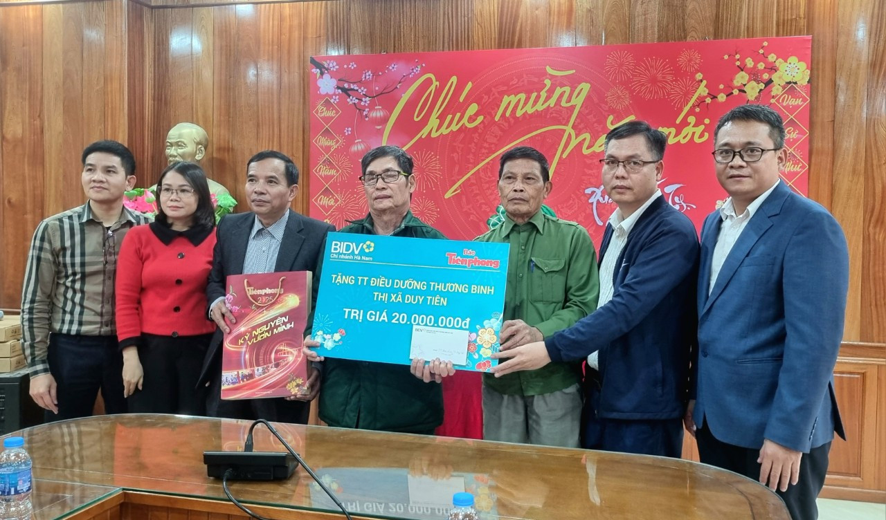 Ông Phạm Nhị Sơn, Phó Giám đốc BIDV Hà Nam và nhà báo Hồ Sỹ Lực trao quà đến các bác thương binh Trung tâm điều dưỡng thương binh Duy Tiên.