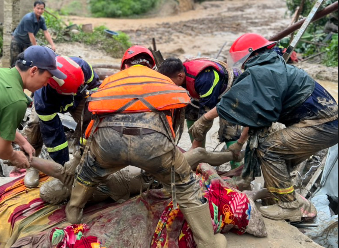 Một nạn nhân được tìm thấy trong bùn đất. Ảnh: N.T Một nạn nhân được tìm thấy trong bùn đất. Ảnh: N.T