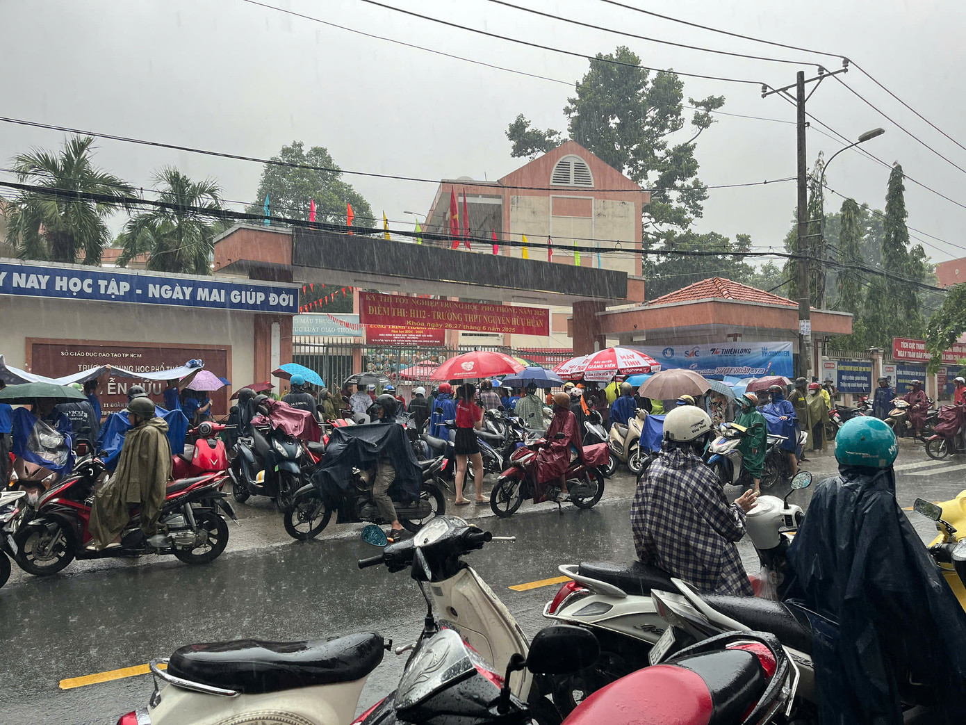 Dù mưa to nhưng có rất nhiều phụ huynh chọn ở lại cổng trường để chờ con thi xong. Ảnh: Trang Huyền