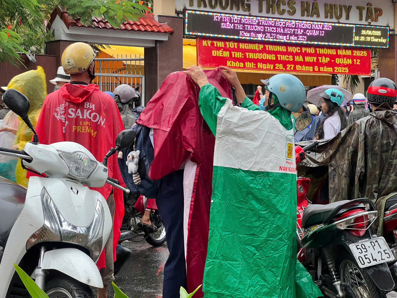 Phụ huynh nhanh chóng che mưa cho con. Ảnh: Phương Anh