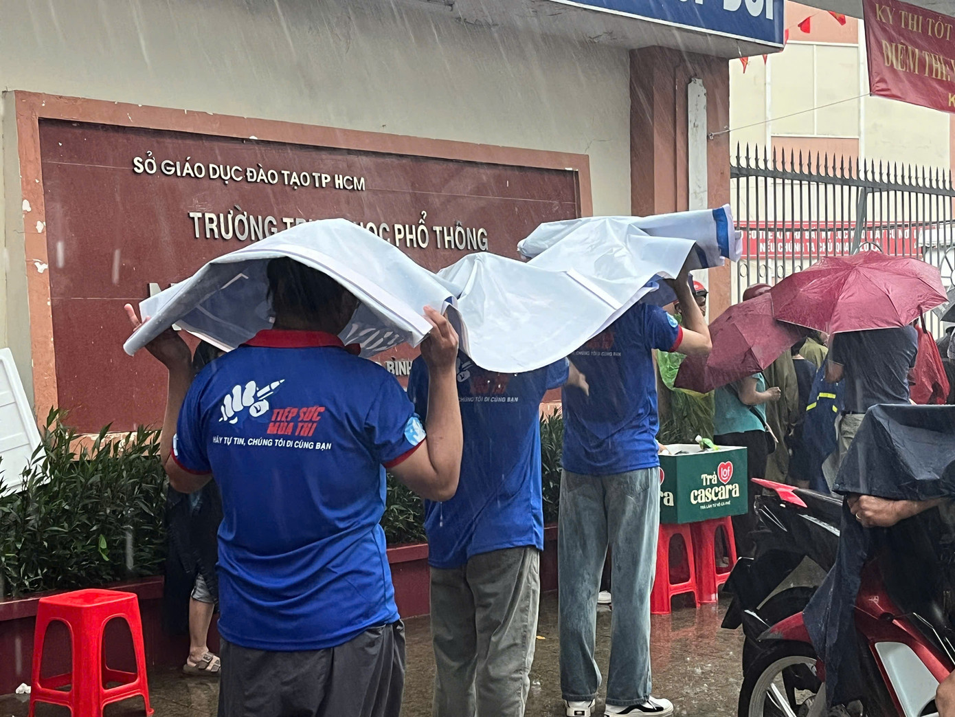 Dù mưa gió, các bạn trẻ vẫn sẵn sàng hành động vì một mùa thi trọn vẹn của đàn em. Ảnh: Trang Huyền