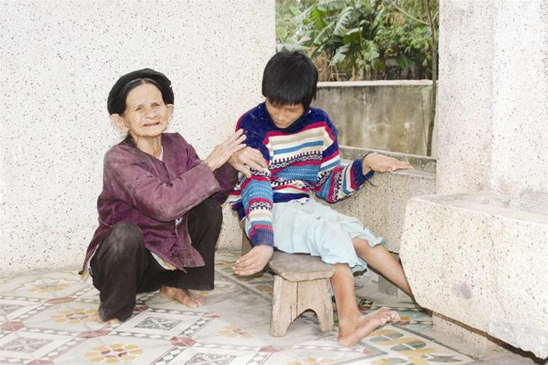 Bà cụ 85 tuổi chăm sóc đứa cháu tàn tật.