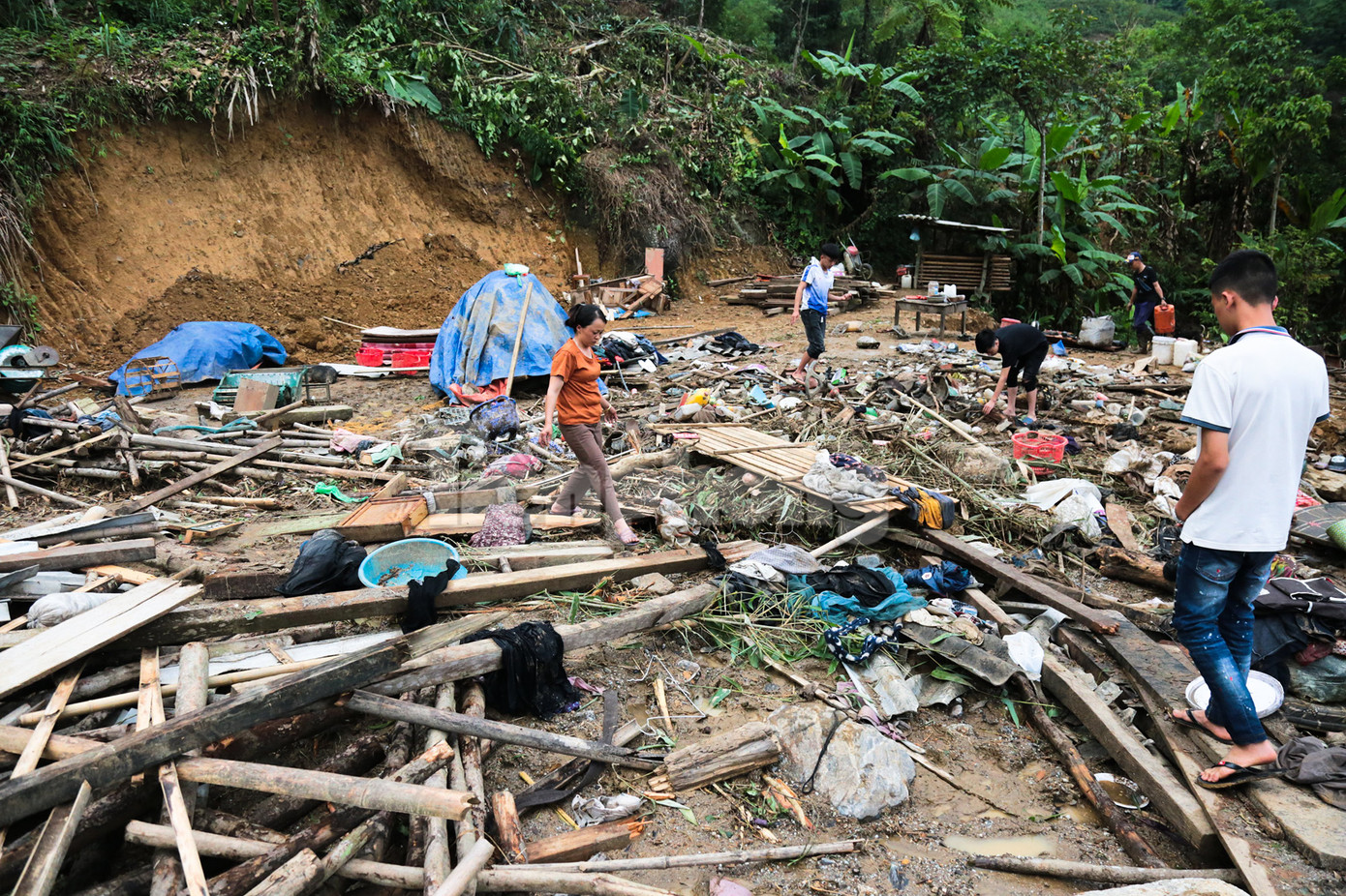 Họ hàng, người thân của gia đình nạn nhân xấu số đang dọn dẹp và tìm kiếm những kỷ vật từ đống đổ nát.