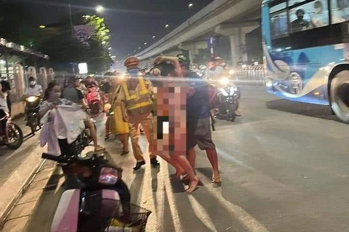 Lực lượng chức năng cùng người dân sau đó đã khống chế cô gái đưa vào vỉa hè, đưa quần áo để mặc. Ảnh: N.H. Lực lượng chức năng cùng người dân sau đó đã khống chế cô gái đưa vào vỉa hè, đưa quần áo để mặc. Ảnh: N.H.