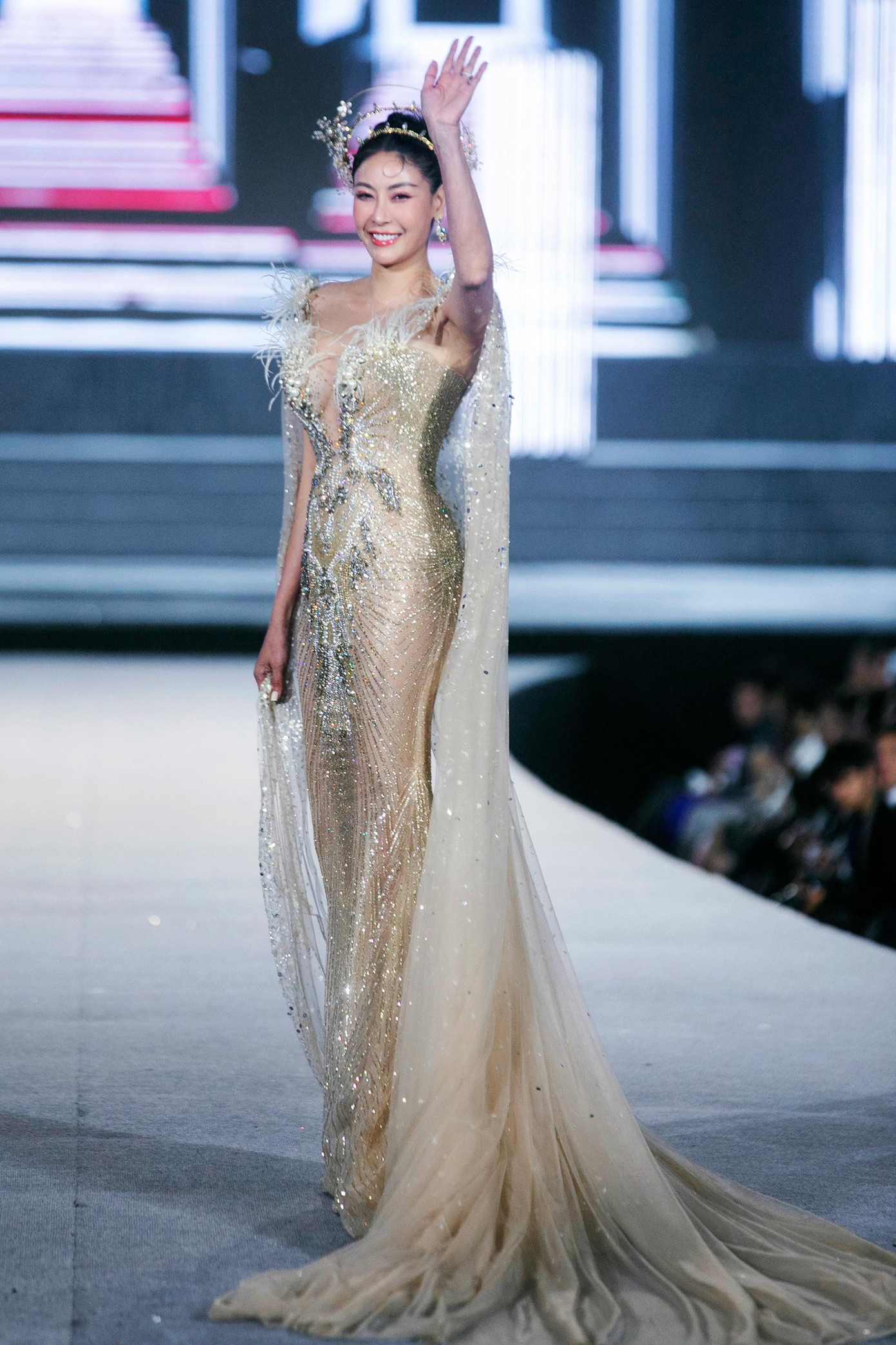 Diện bộ váy ánh bạc xuyên thấu cực kỳ hoành tráng, kết hợp phụ kiện đội đầu lộng lẫy, Hà Kiều Anh kiêu sa tựa 'nữ thần' trên sàn diễn. Sau nhiều năm lui về hậu trường, vóc dáng và nhan sắc của Hoa hậu Việt Nam 1992 vẫn không hề thua kém các đàn em trẻ đẹp.