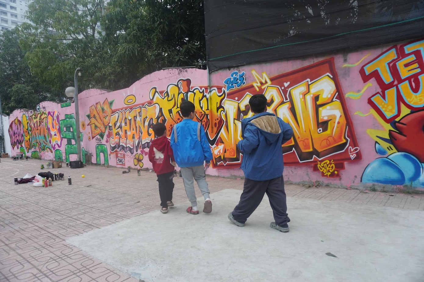 Các em nhỏ trong khu phố hào hứng ngắm nhìn những bức tranh Tết đầy sáng tạo, khiến không khí Tết càng thêm rộn ràng.