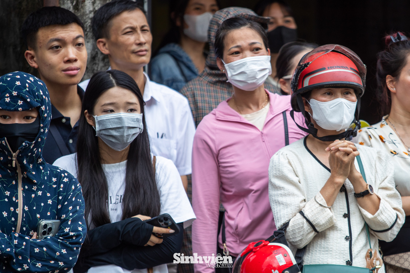 Bên ngoài cổng trường, không khí cũng căng thẳng không kém. Nhiều phụ huynh đứng ngồi không yên, khi thấy con mình và các bạn khác bước ra với vẻ mặt không mấy khả quan, nỗi lo lắng càng hiện rõ. "Bạn nhà cô là thí sinh tự do thi lại, cô thấy bạn bình tĩnh hơn cả cô. Nhưng ngồi chờ con cả buổi, nghe các cháu khác than đề khó mà mình cũng bồn chồn, hồi hộp theo", Chị Nguyễn Thị Mai (quận Ba Đình) tâm sự.