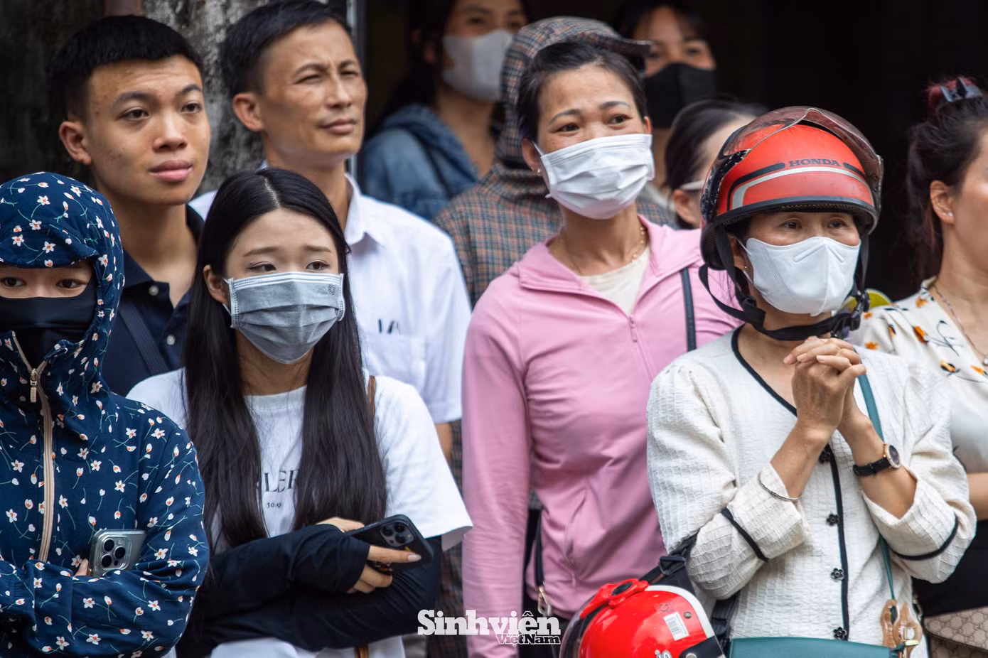 Bên ngoài cổng trường, không khí cũng căng thẳng không kém. Nhiều phụ huynh đứng ngồi không yên, khi thấy con mình và các bạn khác bước ra với vẻ mặt không mấy khả quan, nỗi lo lắng càng hiện rõ. "Bạn nhà cô là thí sinh tự do thi lại, cô thấy bạn bình tĩnh hơn cả cô. Nhưng ngồi chờ con cả buổi, nghe các cháu khác than đề khó mà mình cũng bồn chồn, hồi hộp theo", Chị Nguyễn Thị Mai (quận Ba Đình) tâm sự.