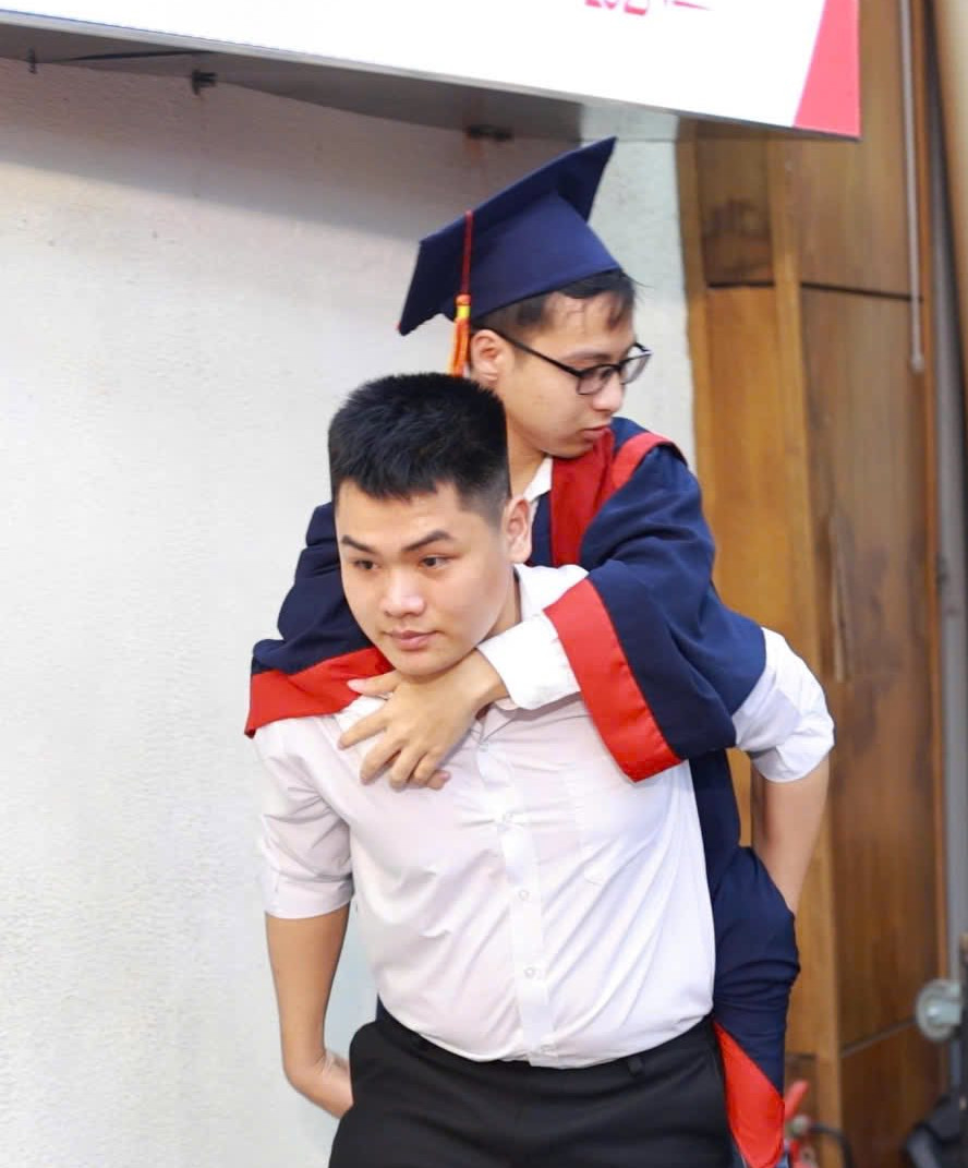 Ngô Văn Hiếu cõng Nguyễn Tất Minh lên bục nhận bằng tốt nghiệp loại Giỏi tại Đại học Bách khoa Hà Nội, chiều 10/5/2025.