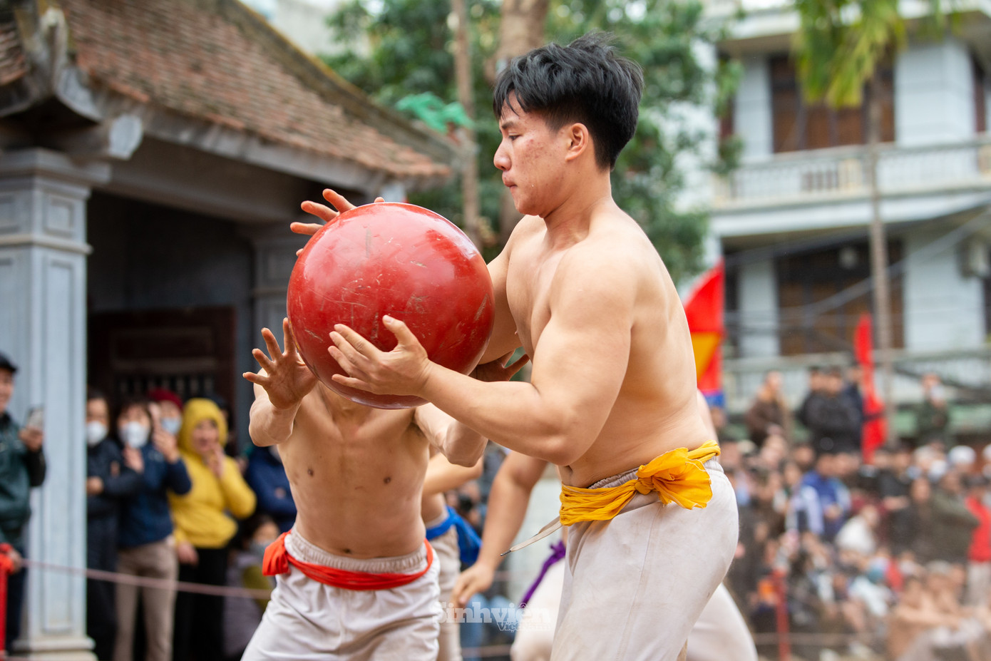 Đoạt cầu từ tay đội đỏ, một vận động viên đội vàng bứt tốc về phía hố để ghi điểm trong khi đồng đội cản trở đối thủ cướp cầu.