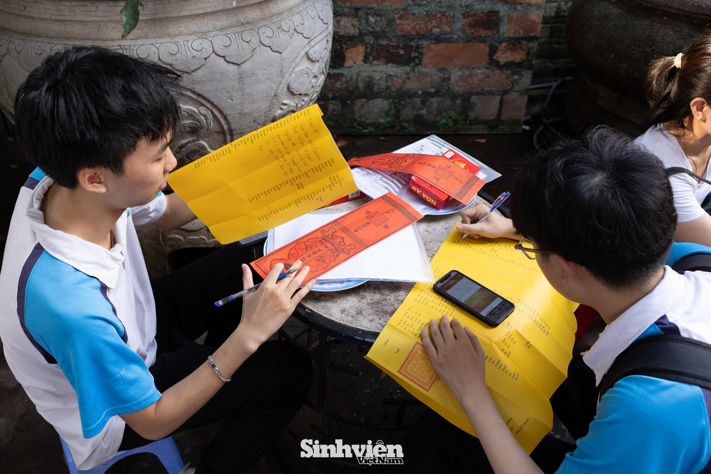 Cùng nhau đến dâng sớ, đôi bạn thân Minh Trí và Minh Tuệ có chung nguyện vọng vào khối ngành khoa học công nghệ. Minh Trí (bên trái) thật thà chia sẻ: "Mục tiêu của em là đỗ vào các trường top đầu như Bách Khoa, PTIT hay USTH. Càng gần ngày thi, chúng em càng hồi hộp nhưng cũng rất mong chờ. Hai đứa tự rủ nhau đến đây, rồi lên mạng tìm hiểu cách viết sớ cho đúng". Trí cười và nói thêm: "Em hy vọng sự thành tâm và chuẩn bị này sẽ mang lại một kỳ thi may mắn và thành công".