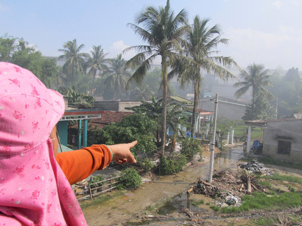 Chị Huỳnh Thị Mạnh chỉ tay sang nhà máy thép ngày ngày xả khói 