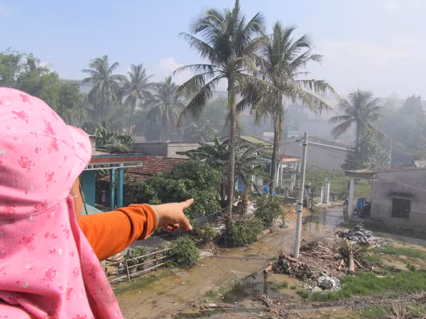Chị Huỳnh Thị Mạnh chỉ tay sang nhà máy thép ngày ngày xả khói 
