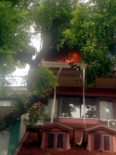 Lính cứu hỏa phải leo ra ban công tầng 3 để dập lửa