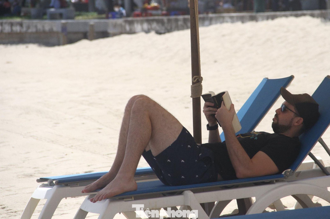 Khách quốc tế nghỉ dưỡng và đọc sách trên bãi biển Nha Trang