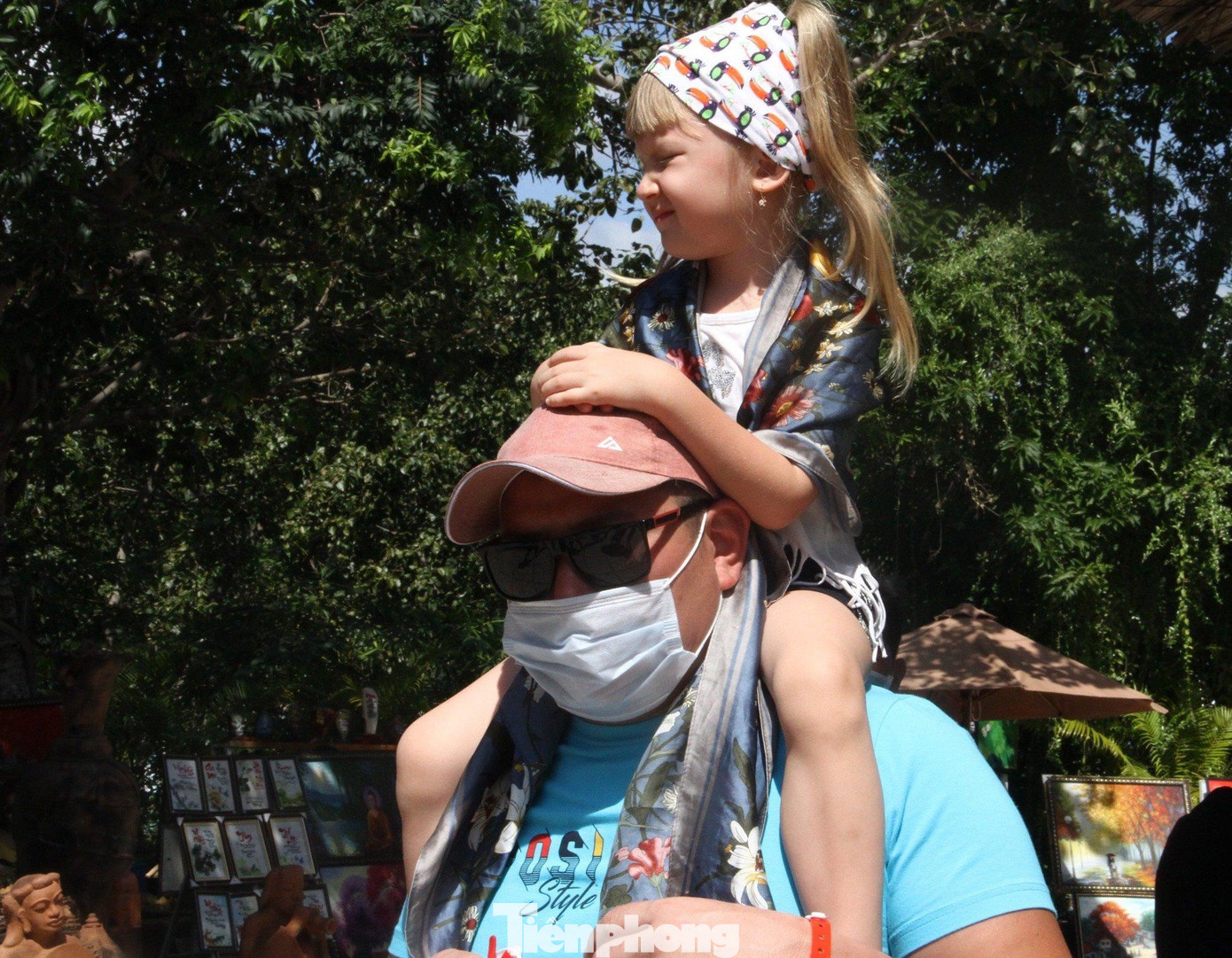 Em bé Nga được bố cõng đi tham quan phố biển