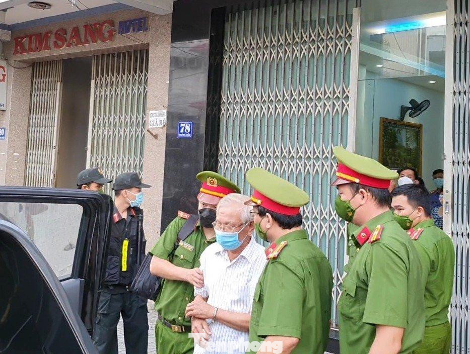 Công an dẫn giải ông Lê Văn Dẽ (áo trắng) ra xe. Ảnh LỮ HỒ.