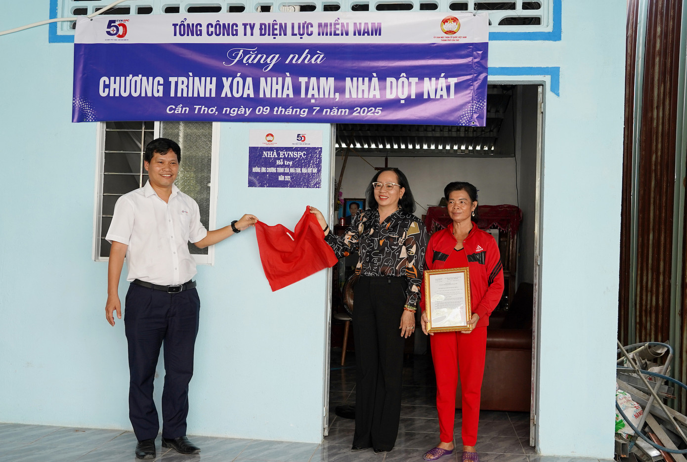 Ông Bùi Quốc Hoan và bà Nguyễn Thuý Hằng thực hiện nghi thức khánh thành nhà tại hộ gia đình bà Trần Ngọc Lây, xã Đồng Thuận