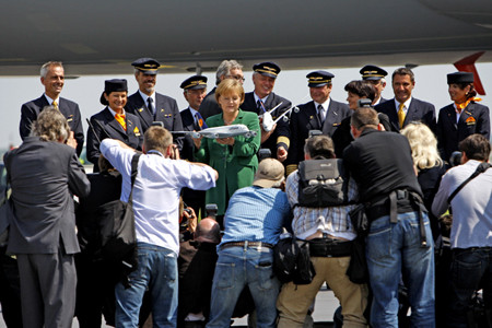 Thủ tướng Đức Angela Merkel (giữa) đang giữ mô hình chiếc Airbus A380 được ông Wolfgang Mayrhuber, Giám đốc điều hành hãng hàng không Lufthansa giới thiệu