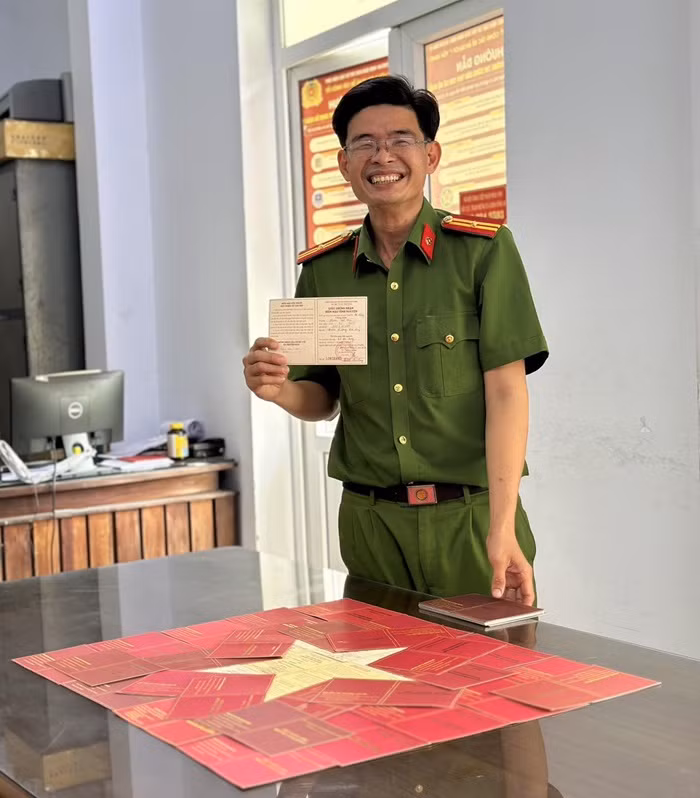 Thiếu tá Phạm Văn Hiếu bên lá cờ Tổ quốc đặc biệt của mình. Ảnh: Bộ Công an