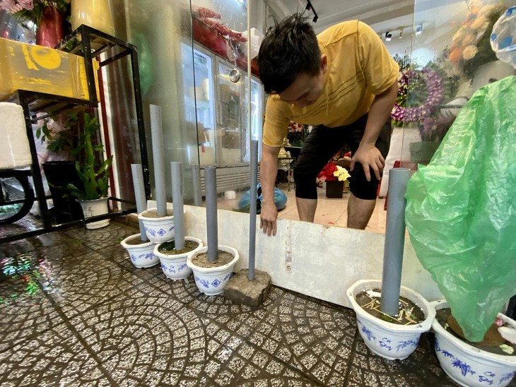 Người dân đường Đống Đa tìm cách ngăn nước tràn từ đường vào nhà. Ảnh: Danang Viewers Người dân đường Đống Đa tìm cách ngăn nước tràn từ đường vào nhà. Ảnh: Danang Viewers