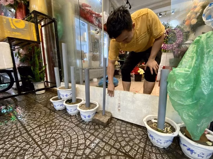 Người dân đường Đống Đa tìm cách ngăn nước tràn từ đường vào nhà. Ảnh: Danang Viewers
