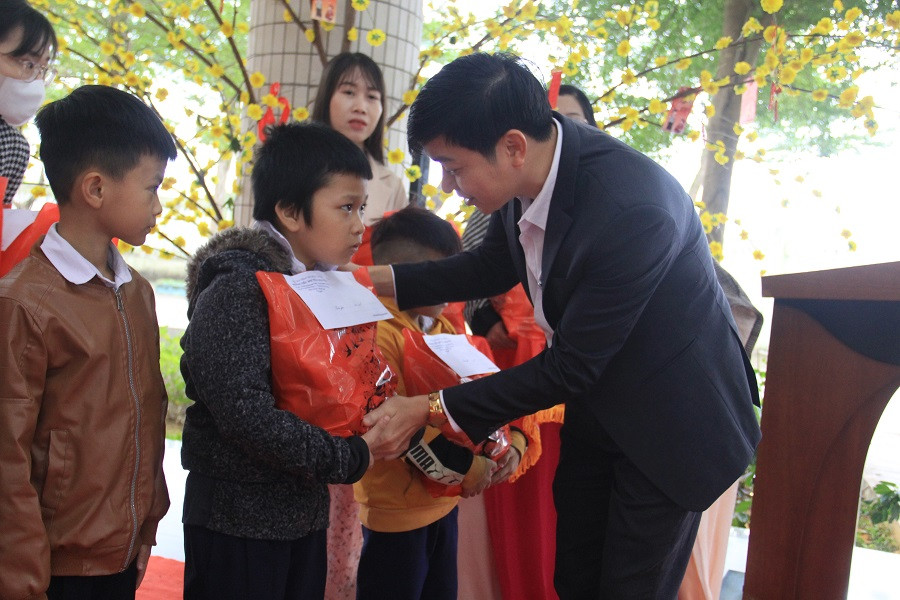 Đại diện phụ huynh trao quà Tết cho các em. Ảnh: Thanh Trần.