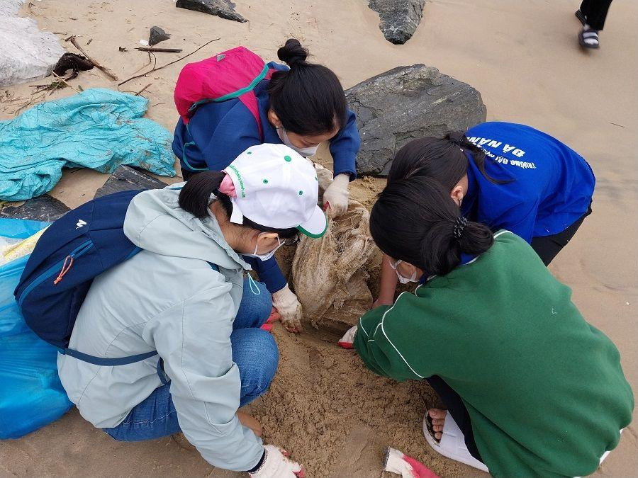Có những rác bị vùi sâu dưới cát, các bạn phải đào lên. (Ảnh: Đầu cầu Đà Nẵng - Xanh Việt Nam)