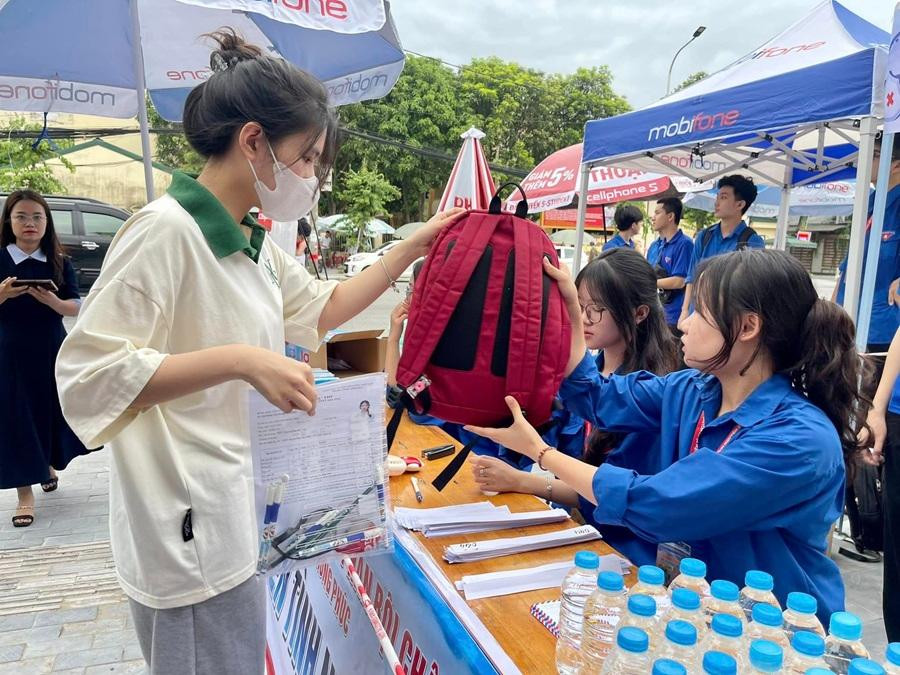 Giữ hộ túi, cặp sách giúp các sĩ tử cũng là một trong những nhiệm vụ của các tình nguyện viên. Ảnh: Fanpage Đoàn khối Doanh nghiệp tỉnh Nghệ An