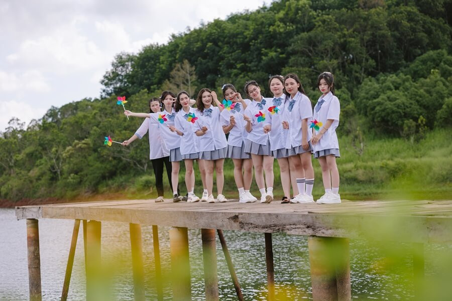 Các nữ sinh lớp 12A cùng nhau chụp ảnh bên dòng sông quê hương.