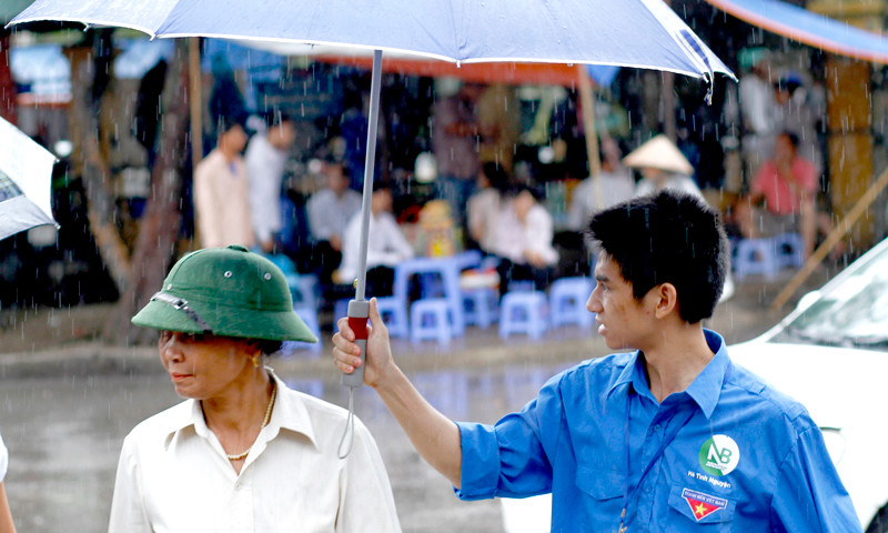 Áo xanh che mưa cho người nhà và sĩ tử trở thành hình ảnh quen thuộc trong sáng 1-7